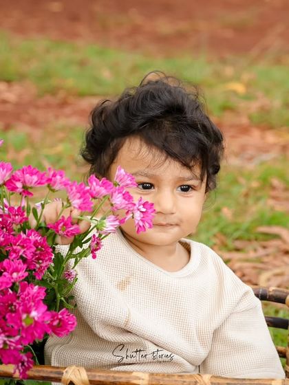 A playful peek-a-boo moment with a flower during this outdoor sitter session.