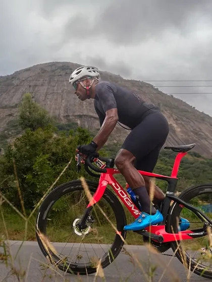 The epic climb. A lone rider powers through the ascent with the majestic Nandi Hills as a backdrop, capturing the beauty and challenge of our signature Nandi Epic road race.