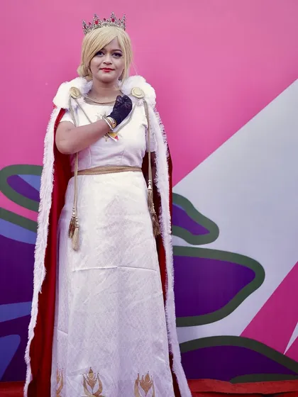 A cosplayer dressed as a royal character poses against a colorful wall. I am always looking for great backdrops to make the subjects stand out.