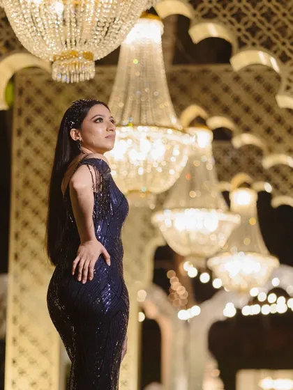 A stunning portrait captured in a walkway of chandeliers. The repeating lights create beautiful leading lines and a luxurious, high-fashion feel for this reception photo.