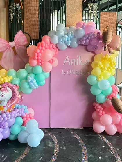 A 'ONE-derful' first birthday filled with unicorn magic. This vibrant pastel rainbow balloon arch, complete with a unicorn and ice cream cone accents, creates a playful and dreamy backdrop for a little one's special day.