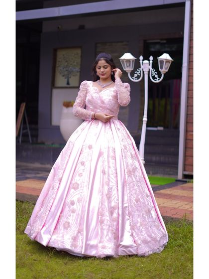 This image showcases the beautiful fit and flow of the pink ball gown. The intricate embroidery on the bodice and skirt adds a touch of sparkle and sophistication, perfect for a fairytale moment.