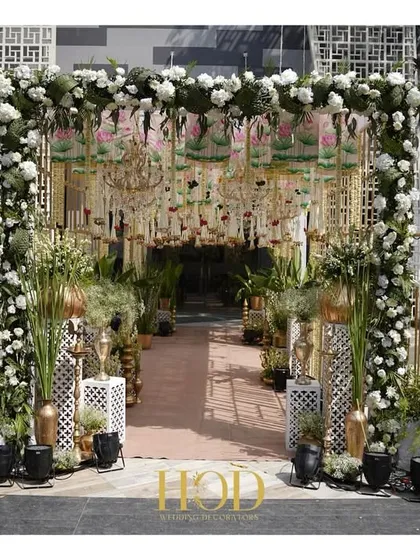 A grand entrance for a Pichwai-themed wedding, featuring floral arches, traditional motifs, and a lush pathway for a culturally rich welcome.