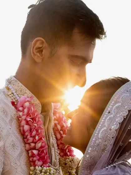 A stunning sun-flare portrait where the sun peeks right between the couple as they gaze at each other. This technique creates a magical, light-filled image that feels warm and intimate.