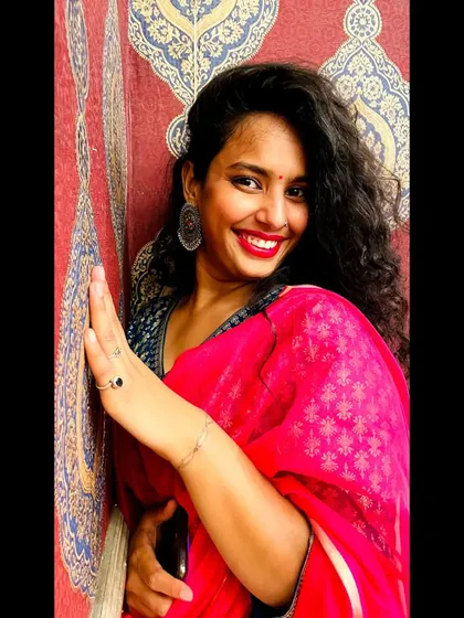 The right makeup and accessories complete any festive look. Here, a bright red lip and statement earrings elevate the entire outfit.