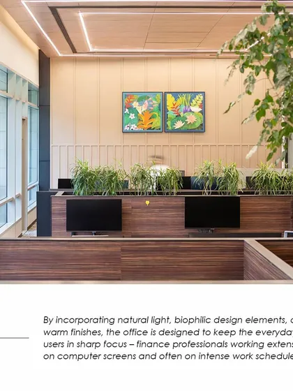 Workstations at the APT office featuring integrated planters and warm finishes. This biophilic design approach is intended to support the well-being of finance professionals who work in a high-intensity environment.
