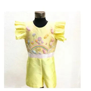 A studio shot of the Candyland Playsuit, showing the ruffled sleeves and detailed candy embroidery. It’s a unique and playful themed outfit.