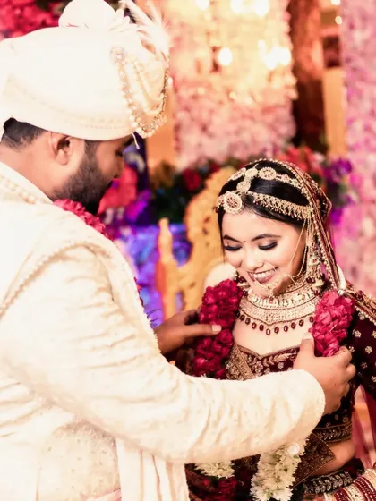 A sweet, unscripted moment during the Varmala ceremony. The groom helps the bride with her garland, and her resulting smile is completely genuine. These are the real moments I love to capture.