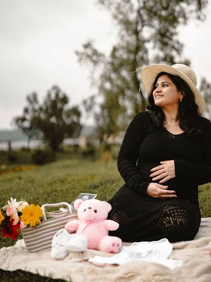 A lovely picnic scene with the mom-to-be sitting and looking off into the distance with a smile. The props around her add to the storytelling.