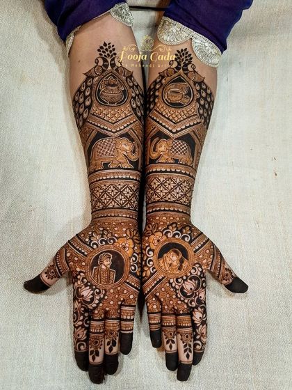 A beautiful bridal design featuring portraits of the couple in medallions, surrounded by traditional elephant motifs and intricate patterns.