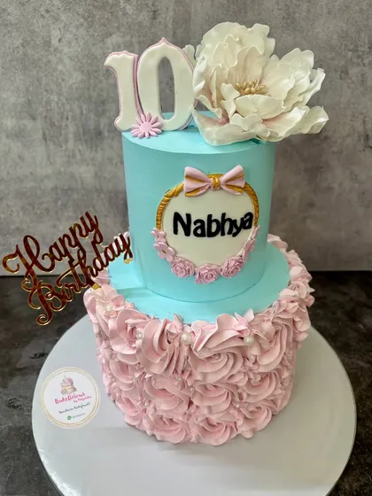 Another angle of the two-tier 10th birthday cake, highlighting the personalized name plaque and the contrast between the two tiers.