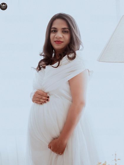 A bright and modern maternity portrait with a high-key lighting setup. The all-white theme creates a pure and angelic look, perfect for a minimalist photoshoot.