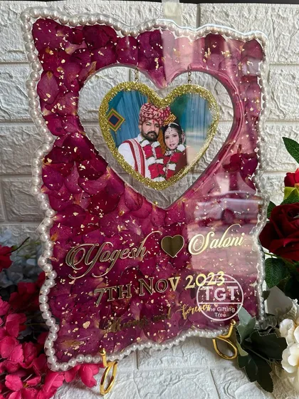The full frame displayed on a stand, showing the unique hanging heart design and pearl border.