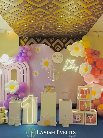 A sweet and cheerful daisy-themed first birthday party, using a pastel color palette, flower props, and classic 'BABY' blocks.