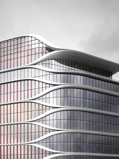 A close-up of the Hilton Kathmandu's facade, showing the interplay between the curved floor plates and the dichroic glass fins that add color and texture.