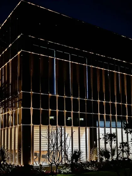 This commercial office block in Zirakpur features a glass and metal grid facade. Our lighting scheme uses integrated fixtures to illuminate the structure from within, creating a sophisticated and modern corporate presence that is both professional and visually compelling.