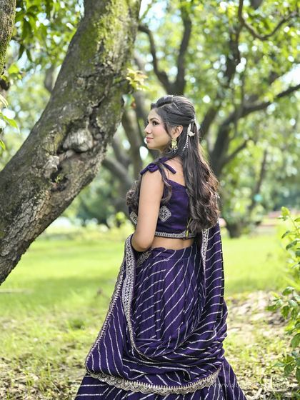 A back view of the purple leheriya lehenga, highlighting the hairstyle and the drape of the dupatta.