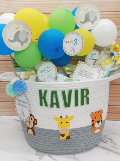 A newborn baby basket for baby Kavir. This jungle-themed basket is personalized with his name and filled with goodies, topped with a balloon bouquet.
