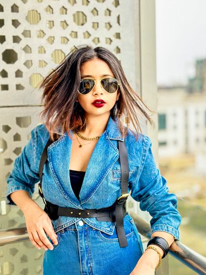A close-up portrait with a bold red lip and sunglasses, completing the powerful workwear vibe.