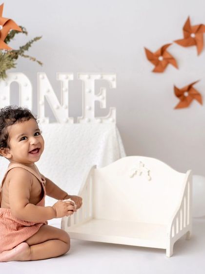 A rustic first birthday setup with orange pinwheels and a happy, crawling baby.