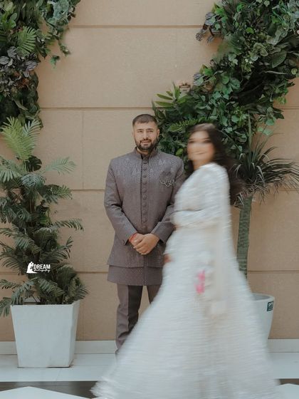 An artistic shot using motion blur to create a dynamic and dreamy effect, focusing on the groom as the bride twirls.