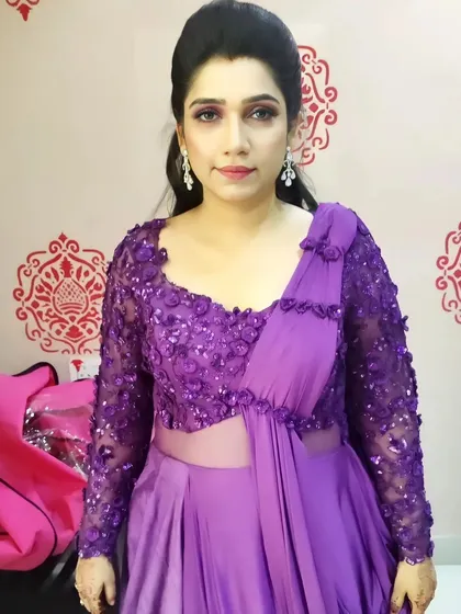 A full view of this client's elegant look in her purple saree. The makeup is soft and glowy, letting her natural beauty and the stunning outfit shine.