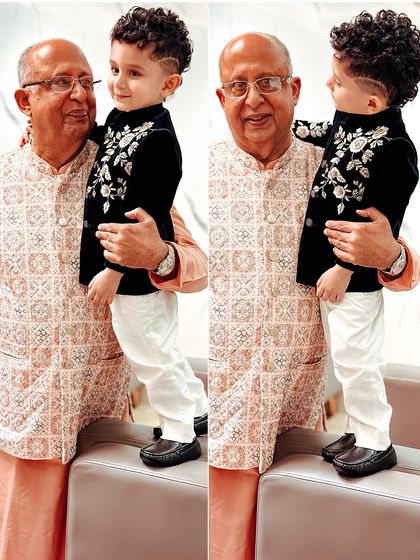 A heartwarming moment between grandfather and grandson, who is dressed in our sophisticated black velvet Indo-western jacket. Our outfits are made for creating multi-generational memories.
