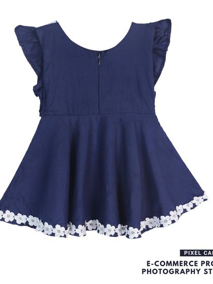 The back of a navy blue baby frock, showing the zipper and lace trim details.