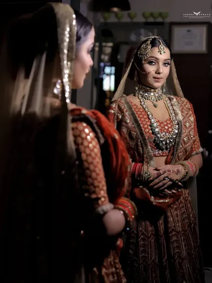 An artistic shot using a mirror to create a reflection, showing the bride looking at herself.