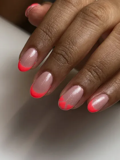 A closer look at the neon pink heart-shaped French tips. This shows the clean lines and precision that go into creating even the most playful designs.