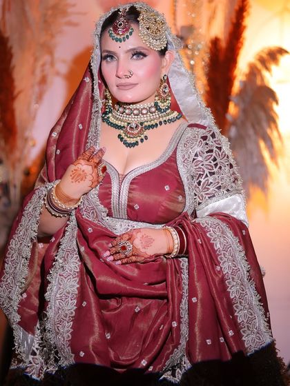 A confident pose from the bride. The makeup is designed to look regal and poised, matching the richness of her velvet outfit.