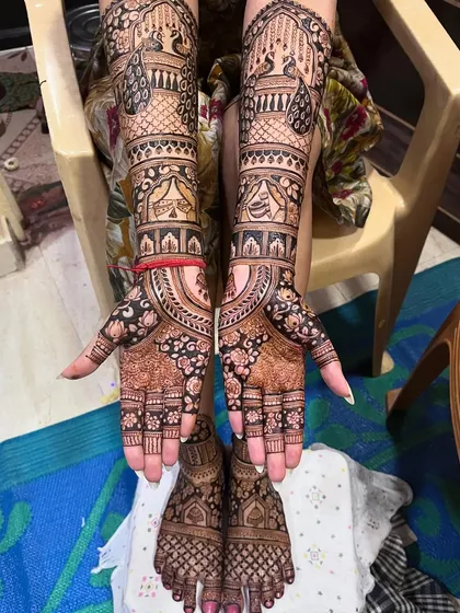 A full view of a bride's hands and feet, with coordinated designs. The peacock and floral theme is elegant and timeless.