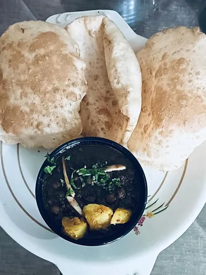A plate of my homemade Chole Bhature. The bhature are soft and fluffy, and the chole are cooked in a thick, spicy gravy.