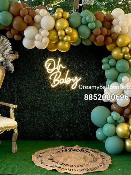 I can create setups in any color scheme you like. This trendy baby shower decoration features a beautiful green wall backdrop, a balloon garland in sage green, brown, and gold, and a comfortable queen chair for the mom-to-be.