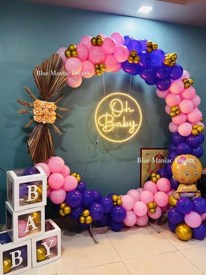 A full view of the 'Oh Baby' shower setup, highlighting the circular balloon garland and the 'BABY' display boxes.
