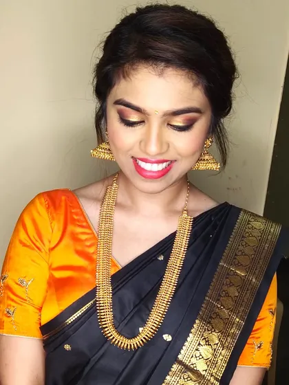 Deepa looking radiant with a golden smoky eye and bright red lipstick. This is a great example of a modern glam look for a wedding party.