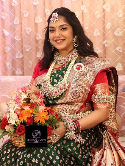 This mom-to-be is glowing in her pink and white floral jewellery set, complete with a matching floral basket filled with colourful flowers for her dohale jevan ceremony.