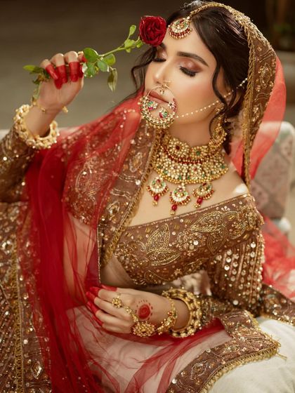 This is the same breathtaking bridal look from our hero shot. The rich brown lehenga paired with a red dupatta and heavy Kundan jewellery is available for you to rent.