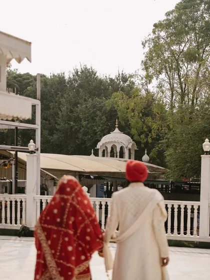 Hand in hand, Kushmeet and Aishwarya walk towards the Gurudwara, and their new life together. This frame captures the reverence and shared journey of their Anand Karaj ceremony, set against the serene backdrop of their faith.
