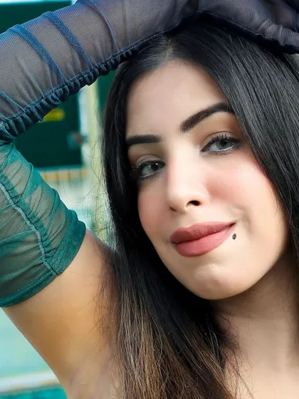 A striking close-up portrait highlighting the model's features and the unique sheer gloves. Indoor shoots allow for this kind of detailed focus without outdoor distractions.