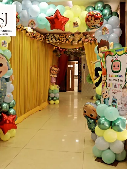 The entrance to the Cocomelon party at Janakpuri Club, with a welcoming balloon arch and character cutouts.