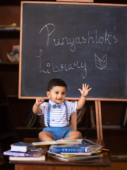 A happy wave from the birthday boy at his own personal library, a creative and personalized first birthday photoshoot concept.