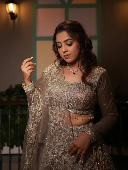 A beautiful portrait of the bride, showcasing the intricate details of her engagement lehenga and her soft makeup.