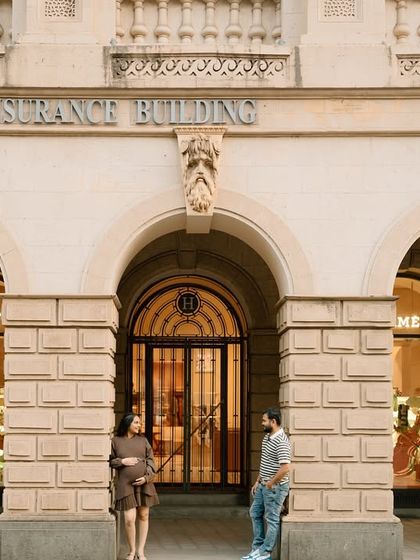 A wide shot showcasing the grandeur of the location and the intimate story of the couple. I love using Mumbai's unique spots for maternity shoots.