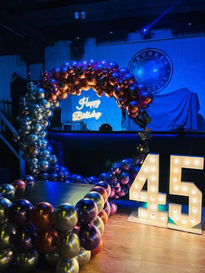 Another view of the impressive 45th birthday setup, showing how the balloon arch frames the DJ booth and dance floor.