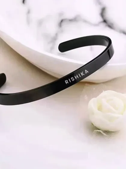 For a more modern look, I offer this black metal kada with a custom name engraving. It's a sleek and stylish accessory for men.