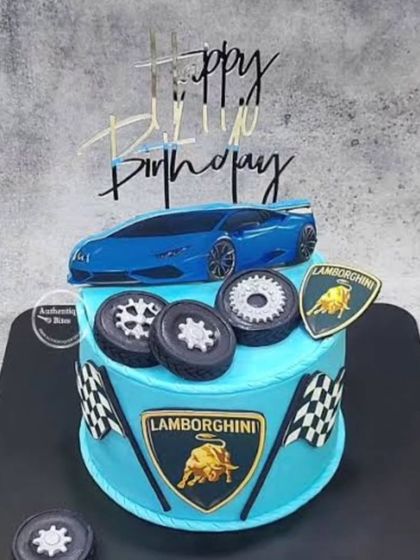 A cool Lamborghini cake in bright blue. The design features the Lamborghini logo, a car topper, and edible tires.