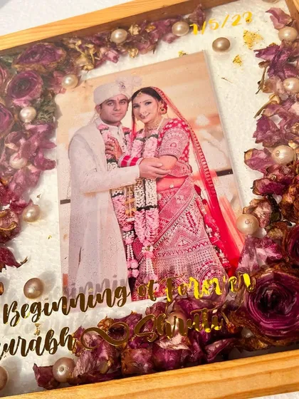 This teak wood frame is a bestseller for a reason. The rich color of the wood beautifully complements the preserved deep red roses and the couple's wedding attire.