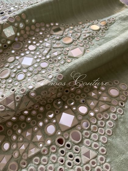 A close-up of the geometric patterns created by the hand-stitched mirrors.