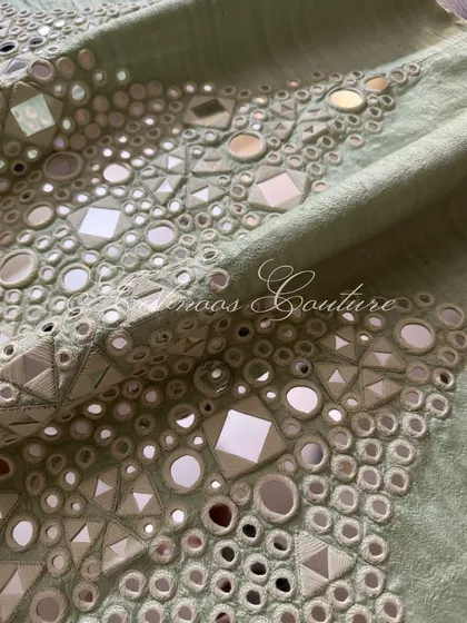 A close-up of the geometric patterns created by the hand-stitched mirrors.